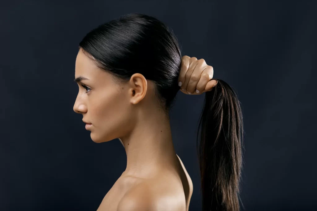 side view of a woman holding her black hair utc